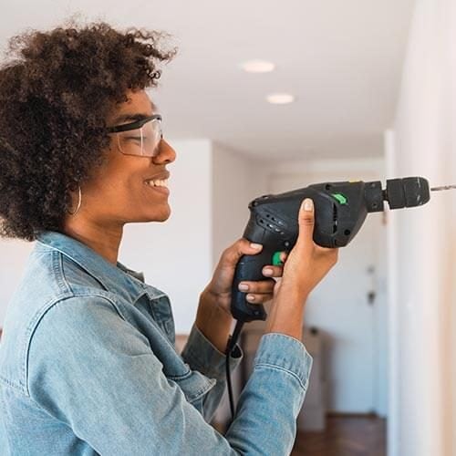 Woman drilling into wall