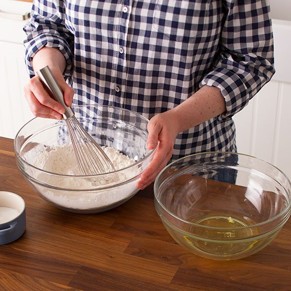 Person using a whisk to mix together the dry ingredients